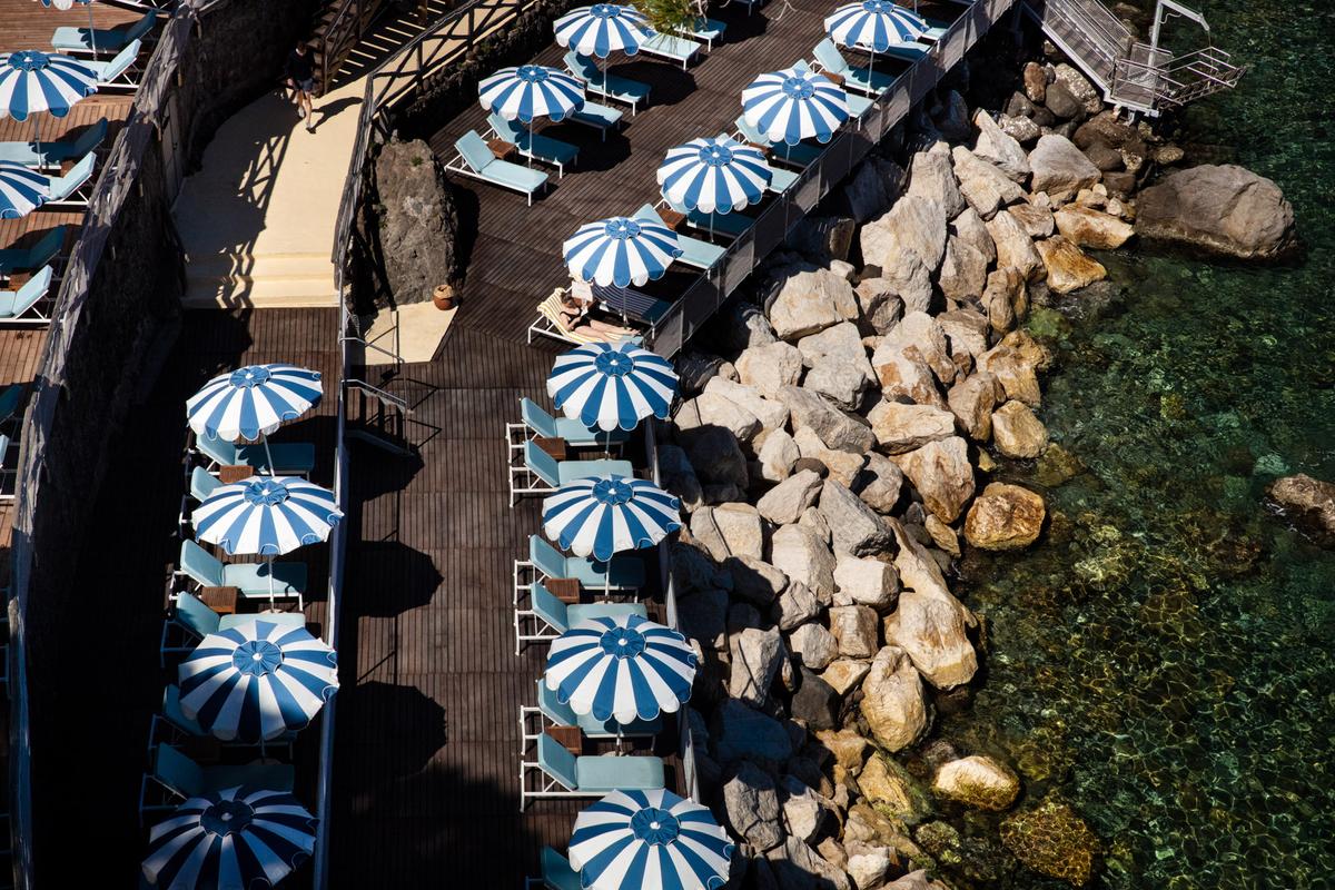 mezzatorre-hotel-and-thermal-spa-rocky-beach-with-sunbeds-and-whiteblue-umbrellas